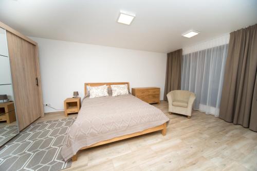 una camera da letto con un letto grande e una sedia di Petro delux apartments a Kaunas