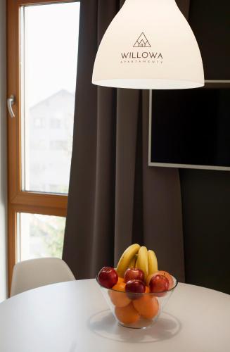 a bowl of fruit on a table under a lamp at Apartamenty Willowa in Szczyrk