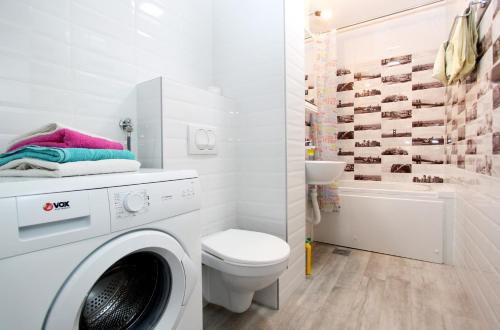 a bathroom with a washing machine and a toilet at Penthouse Novi Beograd in Belgrade
