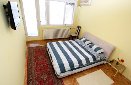 a bedroom with a bed with a rug and a window at Penthouse Novi Beograd in Belgrade