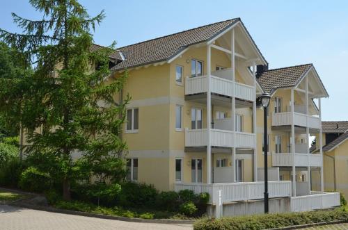 a yellow building with white balconies and a street light at Wohnpark Stadt Hamburg - Apt. 30 in Binz