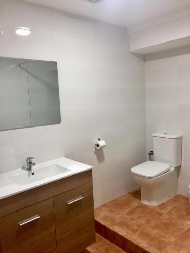 a bathroom with a toilet and a sink and a mirror at Apartamento Valencia in Catarroja