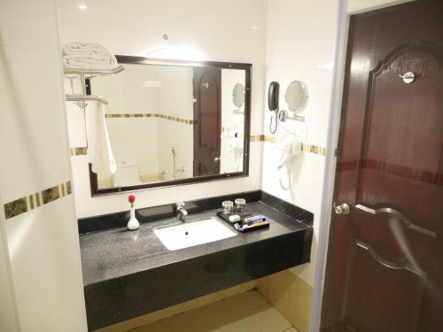 a bathroom with a sink and a mirror at AVS Imperiaa Karaikal in kāraikāl