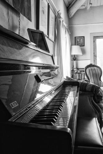 an empty piano in a living room with a chair at Viandanti, Artisti e Sognatori in Comano