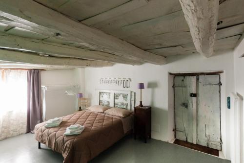 a bedroom with a bed and a wooden ceiling at Viandanti, Artisti e Sognatori in Comano