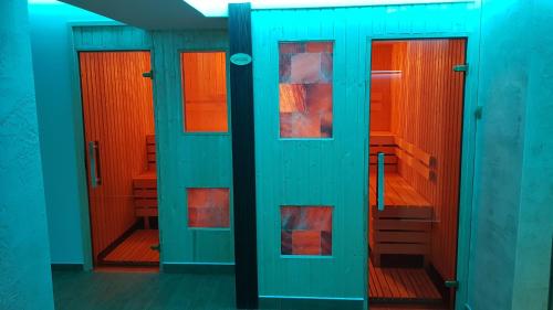 a row of doors in a bathroom with orange at Hotel Vidikovac in Zvornik