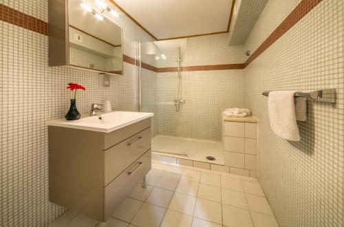 a bathroom with a sink and a shower and a toilet at Hotel Rhodos Morzine in Morzine