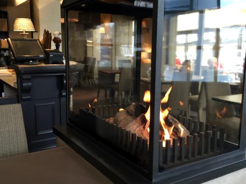 a fireplace in a restaurant with flames in it at Logies Graaf Van Vlaanderen in Bruges