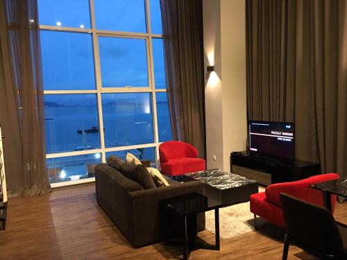 a living room with a couch and chairs and a large window at Urbano Luxury Maritime Suite in George Town