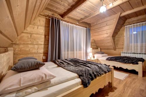 sypialnia z 2 łóżkami w drewnianym domku w obiekcie Pokoje gościnne "U Prusa" w Murzasichlu