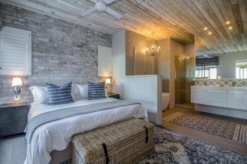 a bedroom with a large bed and a bathroom at The Quarter Deck in Kenton on Sea