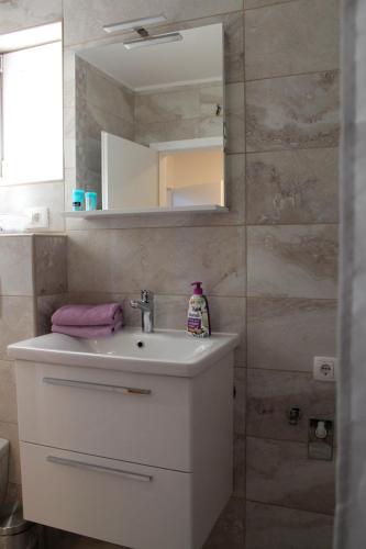 a bathroom with a sink and a mirror at Apartments Tea in Podaca