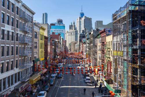 uma rua urbana movimentada com trabalhadores da construção e veículos em Hotel Mimosa em Nova York