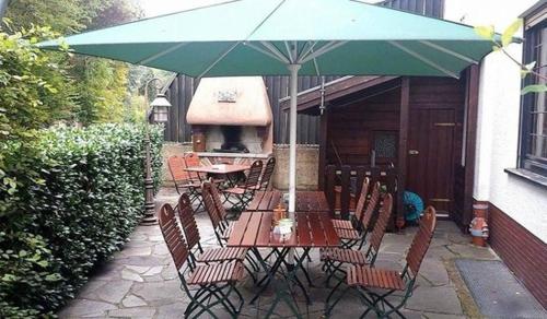 una mesa y sillas con una sombrilla en el patio en Gasthof Schmitt, en Merzig