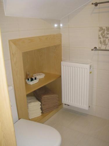 a bathroom with a toilet and some towels and a radiator at Osada Łopuszna in Łopuszna