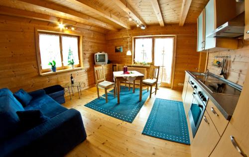 Am Sonnenhang في ايمنستادت ام الغو: غرفة معيشة مع أريكة زرقاء وطاولة