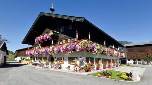 budynek z kwiatami na boku w obiekcie Thomanhof Chalet-Appartement w mieście Saalfelden am Steinernen Meer