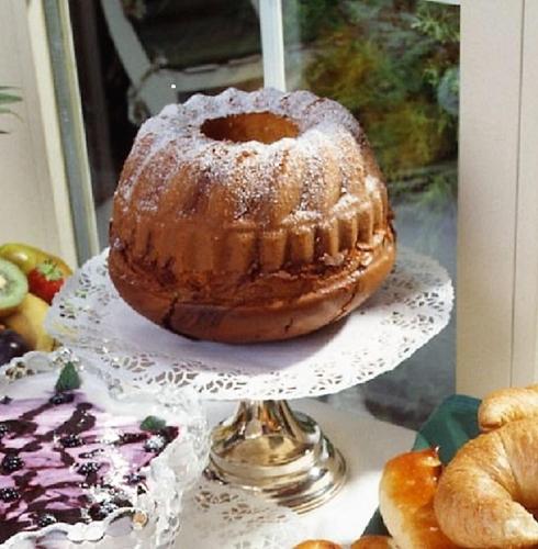 a bundt cake sitting on a plate on a stand at Hotel Mozart in Rorschach