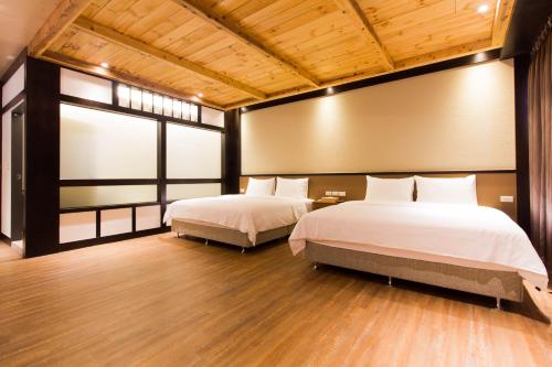 two beds in a room with two windows at 日光微醺 in Luodong