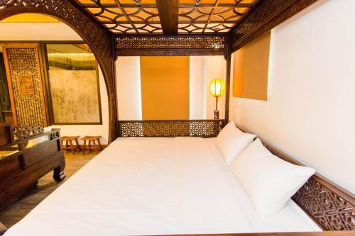 a bedroom with a white bed in a room at 日光微醺 in Luodong