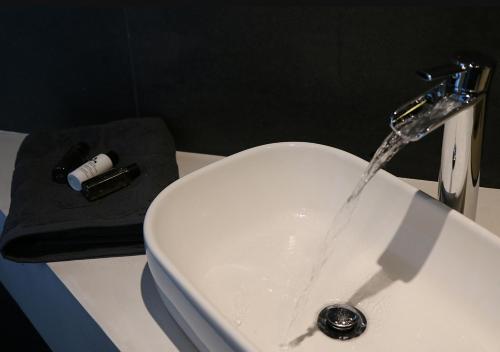 a bathroom sink with water running from a faucet at Hotel Goodnight Antwerp in Antwerp