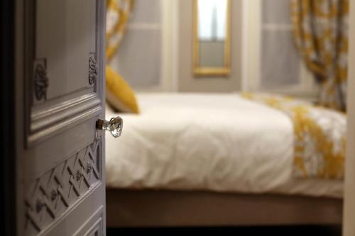 a door to a bedroom with a bed with white sheets at Au Jeu de Paume in Épernay