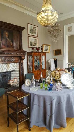 a table in a living room with a chandelier at Au Jeu de Paume in Épernay