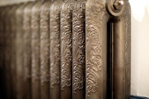 a close up of a metal radiator with designs on it at Au Jeu de Paume in Épernay