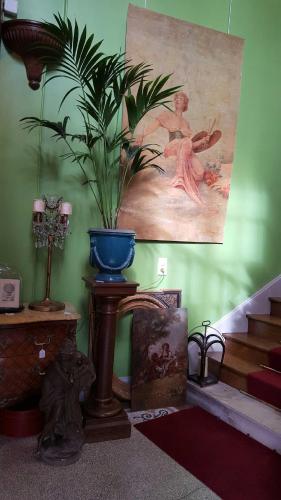 a room with a potted plant on a table and stairs at Au Jeu de Paume in Épernay