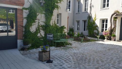 a sign in front of a building with a hotel sign at Au Jeu de Paume in Épernay