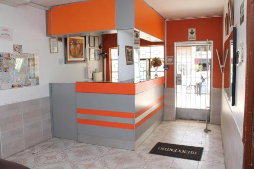 a restaurant with an orange and white counter in a room at Hotel San José in Piura