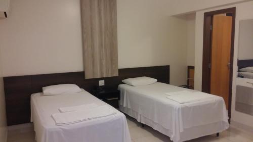 a hospital room with two beds and a mirror at Executivo Hotel in Montes Claros