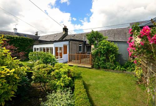 a garden view of a house with a yard at Granny’s Cottage in Newcastleton