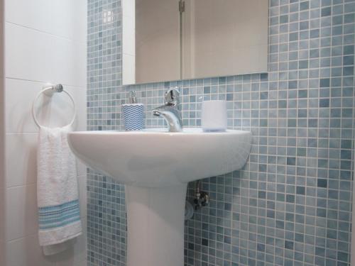 a bathroom with a sink and a mirror and blue tiles at Casa Zé Bonito II in Cascais