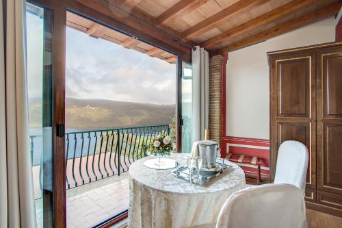 a dining room with a table and a balcony at Hotel Castel Vecchio in Castel Gandolfo