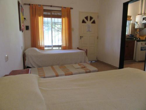 1 dormitorio con 2 camas y puerta a la cocina en Complejo Molino de las Termas, en Gualeguaychú