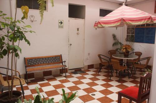 a room with a table and chairs and an umbrella at Hotel San José in Piura