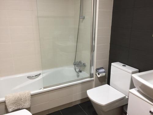 y baño con ducha, aseo y lavamanos. en Luxury Apartament Calle Pizarro Tenerife en La Mareta