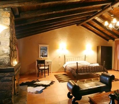 a bedroom with a bed and a table and a chair at Grand House Suites in Palaios Agios Athanasios