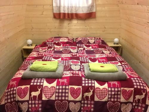um quarto com uma cama com uma colcha vermelha e branca em Inn-side ADVENTURE CABINS em Haiming