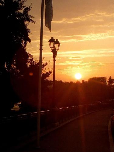 a street light with the sunset in the background at Hôtel Central in Pau