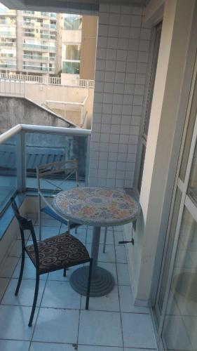 a table and two chairs on a balcony with a table and chair at Apart Hotel Quartier Latin in Vitória