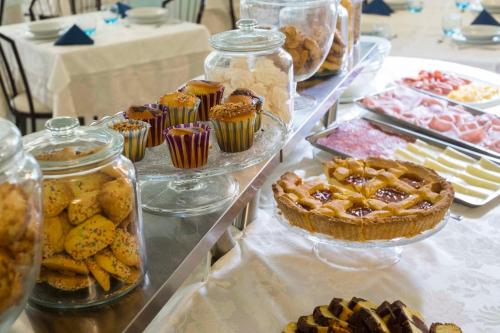 a buffet with pies and desserts in glass jars at Hotel Ricchi in Rimini