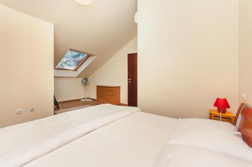 a bedroom with a white bed in a room at Modern new flat next to river Cetina in Omiš