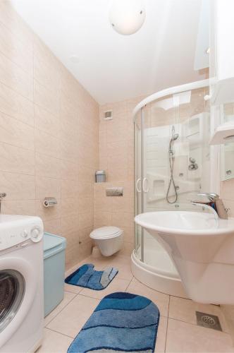 a bathroom with a sink and a washing machine at Modern new flat next to river Cetina in Omiš