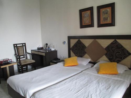 a bedroom with a large bed with two yellow pillows at East End Retreat in New Delhi