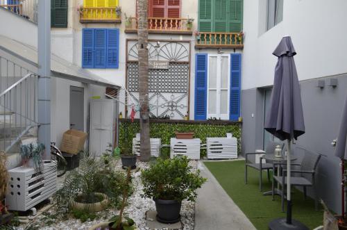a patio with an umbrella and a table and chairs at St. Lazaros Studios in Larnaka
