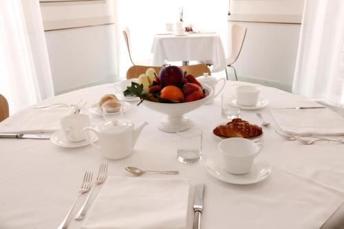 a white table with a bowl of fruit on it at Hotel Grand'Italia in Padova