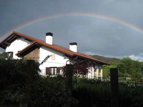 a house with a rainbow in the sky at Hotel Aldori Landetxea - Reserva de la Biosfera Urdaibai - Adults Only in Muxika
