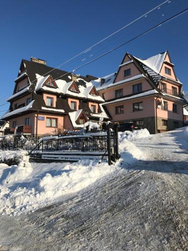 a large building in the snow with a ski lift at Pokoje u Borzana in Biały Dunajec